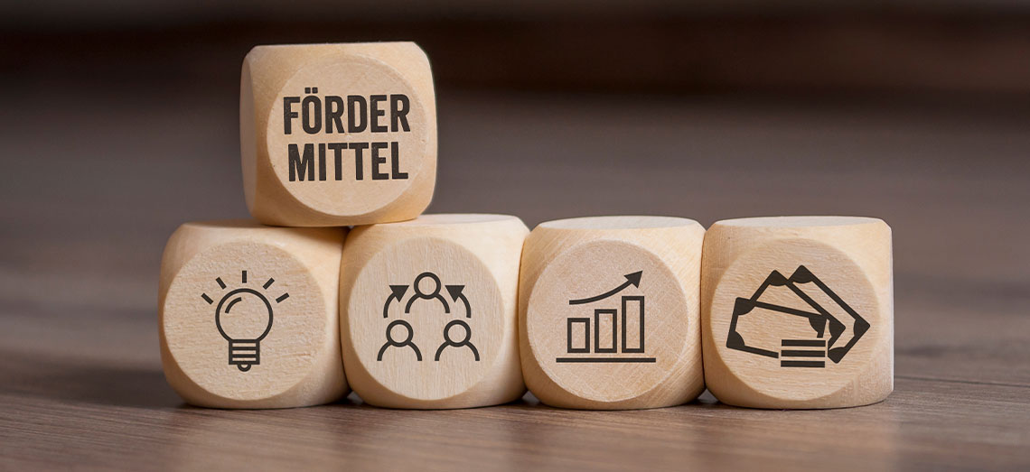 s-Foedermittel-Wuerfel Holzwürfel gestapelt. Auf dem einen Würfel steht Fördermittel.