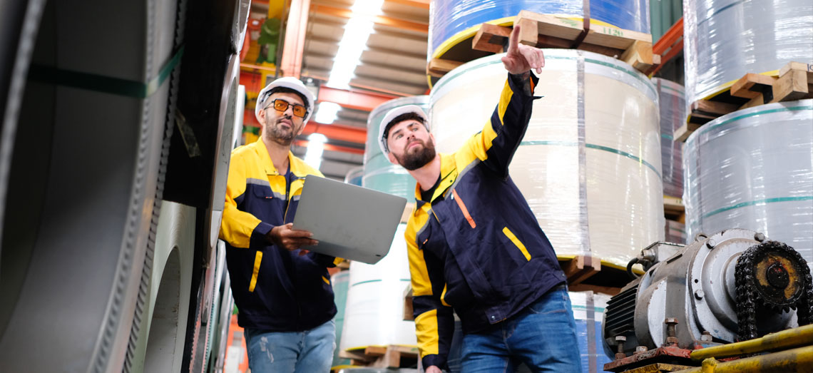 Zwei Männer tauschen sich aus und tragen einen Schutzhelm.