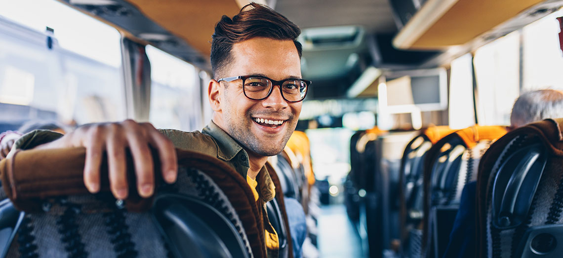ZB-Meister-Kraftverkehr-04 Ein Mann sitzt im Bus und lächelt.