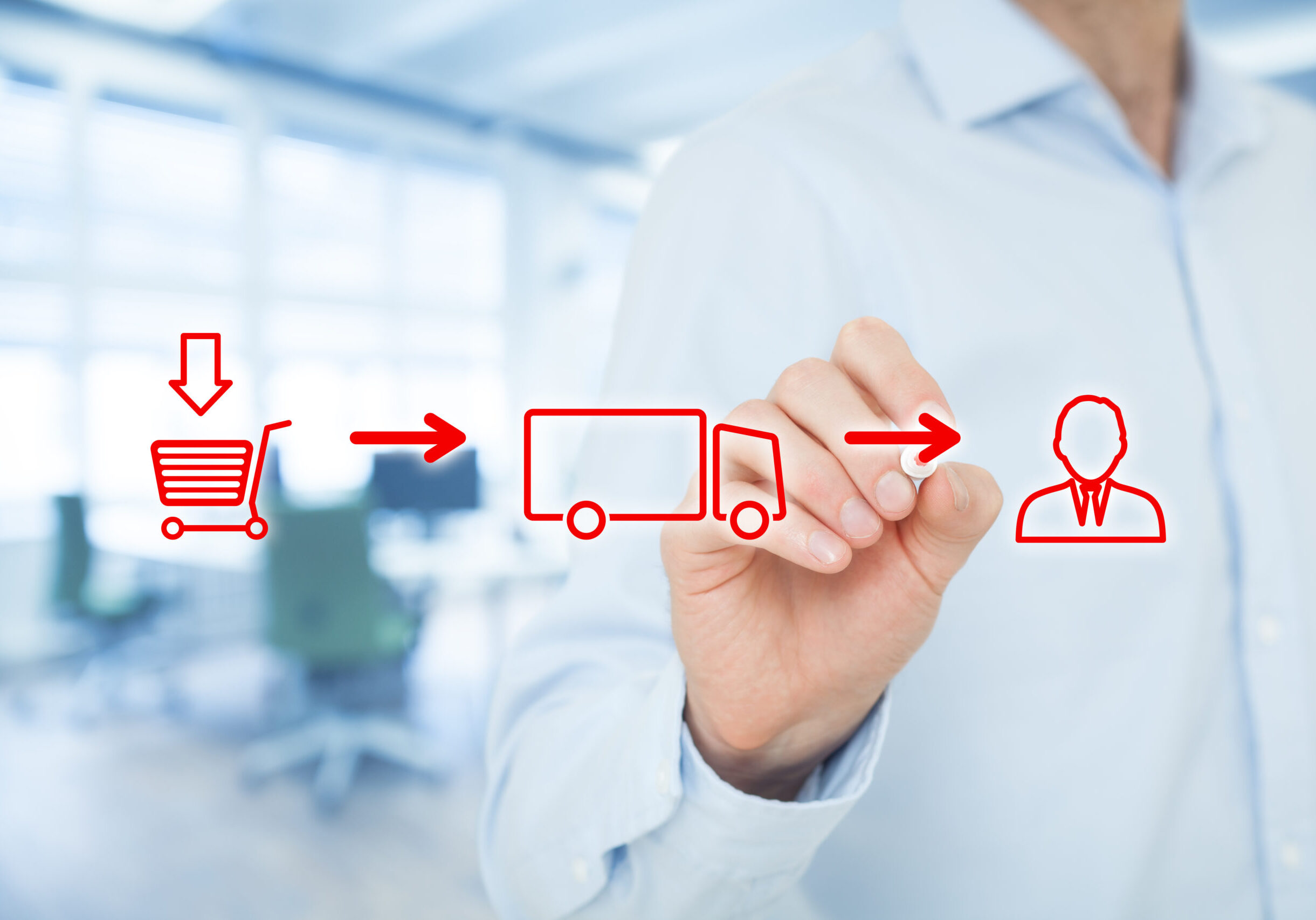 Eine Hand zeichnet diese Symbole: Ein Einkaufswagen- LKW- Mensch.